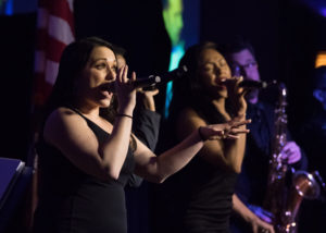 Two women singing with microphones at the 2018 YCEA dinner