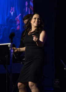 Woman singing with a microphone at the 2018 YCEA dinner